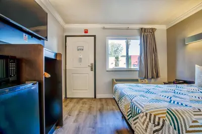 a bedroom with a bed and a window and a door at Motel 6-Menifee, CA in Menifee