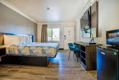 a hotel room with a bed and a desk and a television at Motel 6-Menifee, CA in Menifee