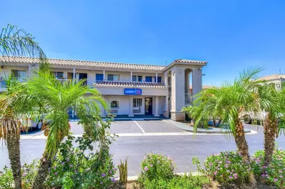 a hotel with palm trees in front of it at Motel 6-Menifee, CA in Menifee