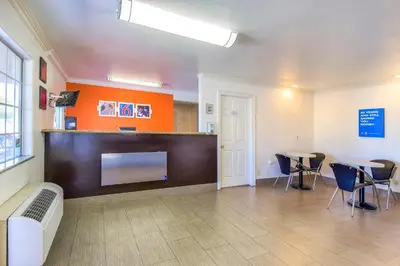 a large room with chairs and a flat screen tv at Motel 6-Menifee, CA in Menifee