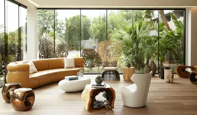 a living room with a couch and tables and windows at Hotel La Jolla, Curio Collection by Hilton in San Diego