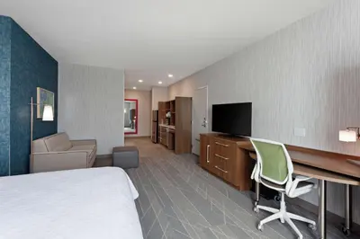 a hotel room with a bed and a desk and a television at Home2 Suites By Hilton Temecula in Temecula