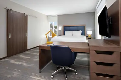 a bedroom with a bed and a desk with a computer at Hampton Inn & Suites San Diego Airport Liberty Station in San Diego