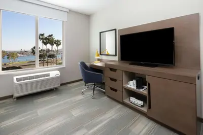 a room with a television and a desk with a chair at Hampton Inn & Suites San Diego Airport Liberty Station in San Diego