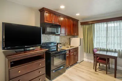 a kitchen with a large flat screen tv on the wall at Quality Inn & Suites El Cajon San Diego East in El Cajon