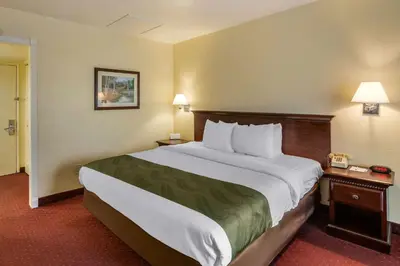 a hotel room with a large bed and two tables at Quality Inn & Suites El Cajon San Diego East in El Cajon