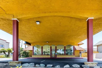 a large building with red columns at Rodeway Inn & Suites Canyon Lake-Menifee West in Canyon Lake