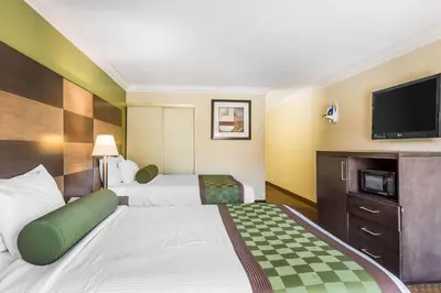 a hotel room with two beds and a flat screen tv at Rodeway Inn & Suites Canyon Lake-Menifee West in Canyon Lake
