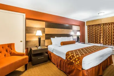 a hotel room with a bed and a chair at Rodeway Inn & Suites Canyon Lake-Menifee West in Canyon Lake