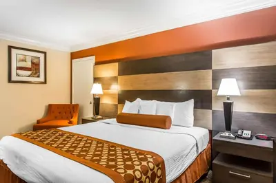 a hotel room with a bed and a chair at Rodeway Inn & Suites Canyon Lake-Menifee West in Canyon Lake