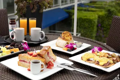 a table with two plates of breakfast foods and drinks at Hotel Indigo San Diego Del Mar by IHG in San Diego