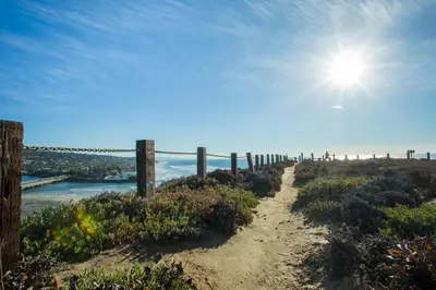 a dirt path with a fence on the beach at Hotel Indigo San Diego Del Mar by IHG in San Diego