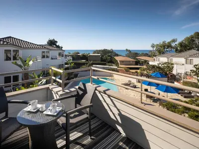 a balcony with a table and chairs and a pool at Hotel Indigo San Diego Del Mar by IHG in San Diego