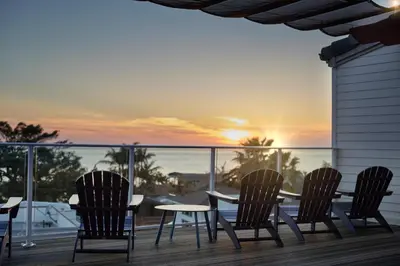 a table and chairs on a deck with a view of the ocean at Hotel Indigo San Diego Del Mar by IHG in San Diego