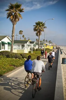 a group of people riding bikes down a street at The Beach Cottages in San Diego