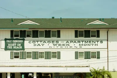 a white building with signs on the side of it at The Beach Cottages in San Diego