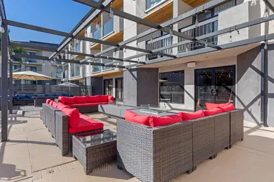 a patio with red chairs and tables and a building at Comfort Inn & Suites Irvine Spectrum in Lake Forest