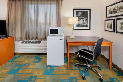 a hotel room with a desk and a microwave at La Quinta Inn & Suites by Wyndham Irvine Spectrum in Irvine