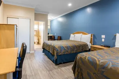 a hotel room with two beds and a bathroom at Rodeway Inn Escondido Downtown in Escondido