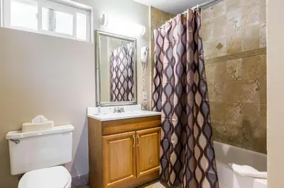 a bathroom with a toilet and a sink and a shower at Rodeway Inn Escondido Downtown in Escondido
