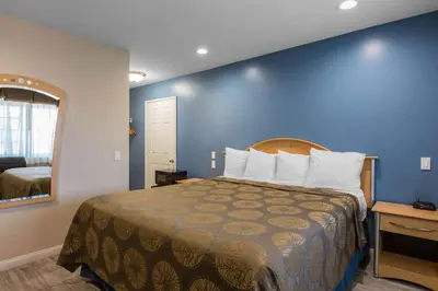 a bedroom with a large bed with a blue wall at Rodeway Inn Escondido Downtown in Escondido