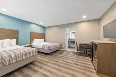 a hotel room with two beds and a flat screen tv at Hotel Palmeras Chula Vista in Chula Vista