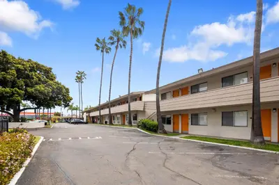 an empty parking lot in front of a building at Hotel Palmeras Chula Vista in Chula Vista