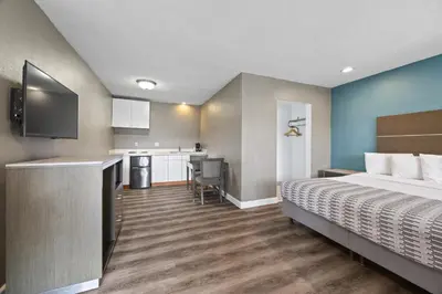 a hotel room with a bed and a kitchen at Hotel Palmeras Chula Vista in Chula Vista