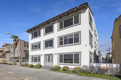 a white building with tables and chairs on a street at 120-Oceanfront Penthouse 5 in San Diego