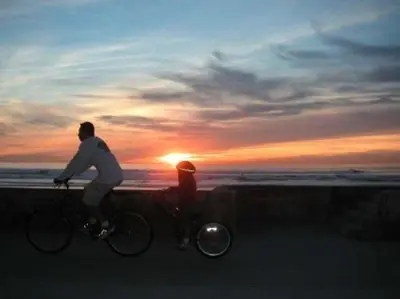 a man and a woman riding a bike on the beach at 120-Oceanfront Penthouse 5 in San Diego