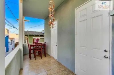 a door to a balcony with a table and chairs at 200-Surf Stars Penthouse in San Diego