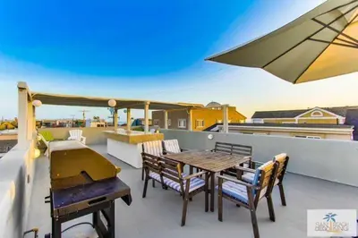 a patio with a table and chairs and an umbrella at 200-Surf Stars Penthouse in San Diego