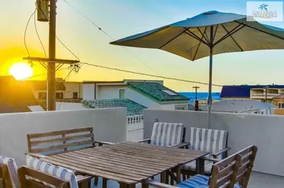 a wooden table with chairs and an umbrella on a balcony at 200-Surf Stars Penthouse in San Diego