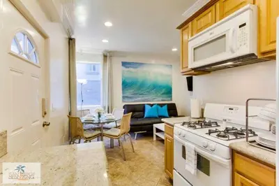 a kitchen with a stove and a living room at 201-Surf Stars Studio in San Diego