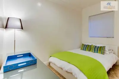 a bedroom with a bed and a table with a lamp at 201-Surf Stars Studio in San Diego