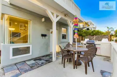 a patio with a table and chairs in front of a house at 201-Surf Stars Studio in San Diego