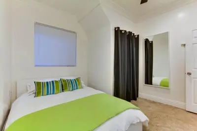 a bedroom with a green and white bed and a mirror at 199-Surf Stars Combo in San Diego
