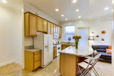 a kitchen with a white refrigerator and a table and chairs at 199-Surf Stars Combo in San Diego