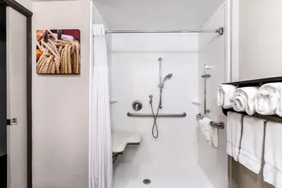 a white bathroom with a shower and a toilet at La Quinta by Wyndham San Diego Mission Bay in San Diego