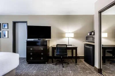 a hotel room with a bed and a desk with a television at La Quinta by Wyndham San Diego Mission Bay in San Diego