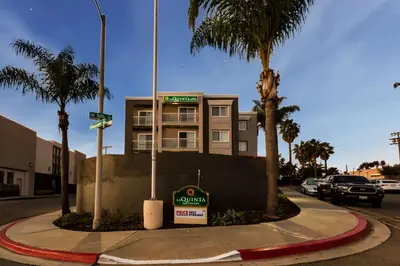 a building on the corner of a street with palm trees at La Quinta by Wyndham San Diego Mission Bay in San Diego