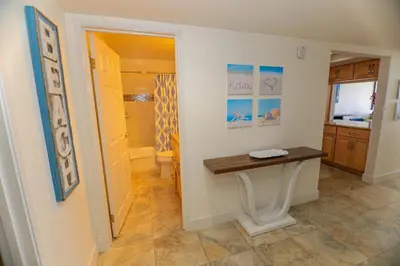 a hallway with a table in a room at Capri Beach Accommodations at Capri By The Sea in San Diego