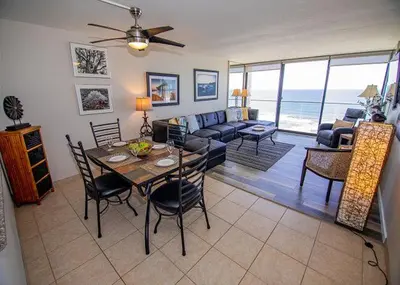a living room with a table and a couch at Capri Beach Accommodations at Capri By The Sea in San Diego