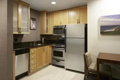 a kitchen with stainless steel appliances and wooden cabinets at Residence Inn San Diego Del Mar in San Diego