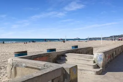 a sandy beach with stairs and people on the beach at 101-Luxury1 in San Diego