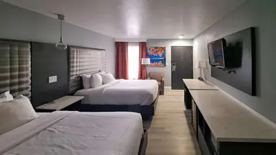 a hotel room with two beds and a desk at Clarion Pointe El Cajon San Diego East in El Cajon
