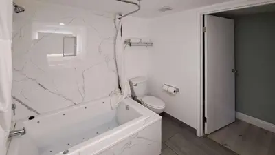 a white bathroom with a white tub and a toilet at Clarion Pointe El Cajon San Diego East in El Cajon