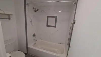 a bathroom with a shower with a tub and a toilet at Clarion Pointe El Cajon San Diego East in El Cajon