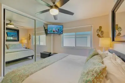 a bedroom with a large white bed with a ceiling fan at 102-Luxury2 in San Diego
