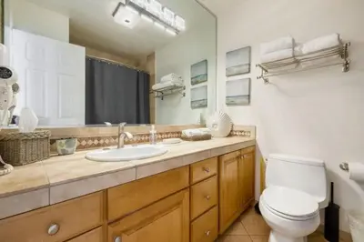 a bathroom with a toilet and a sink and a mirror at 102-Luxury2 in San Diego